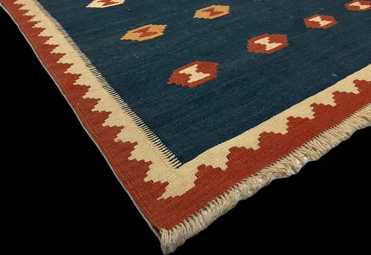 alfombra persa de estilo kilim en dimensiones 238 centímetros de largo por 172 centímetros de ancho con colores principalmente azul y rojo — Esquina y borde