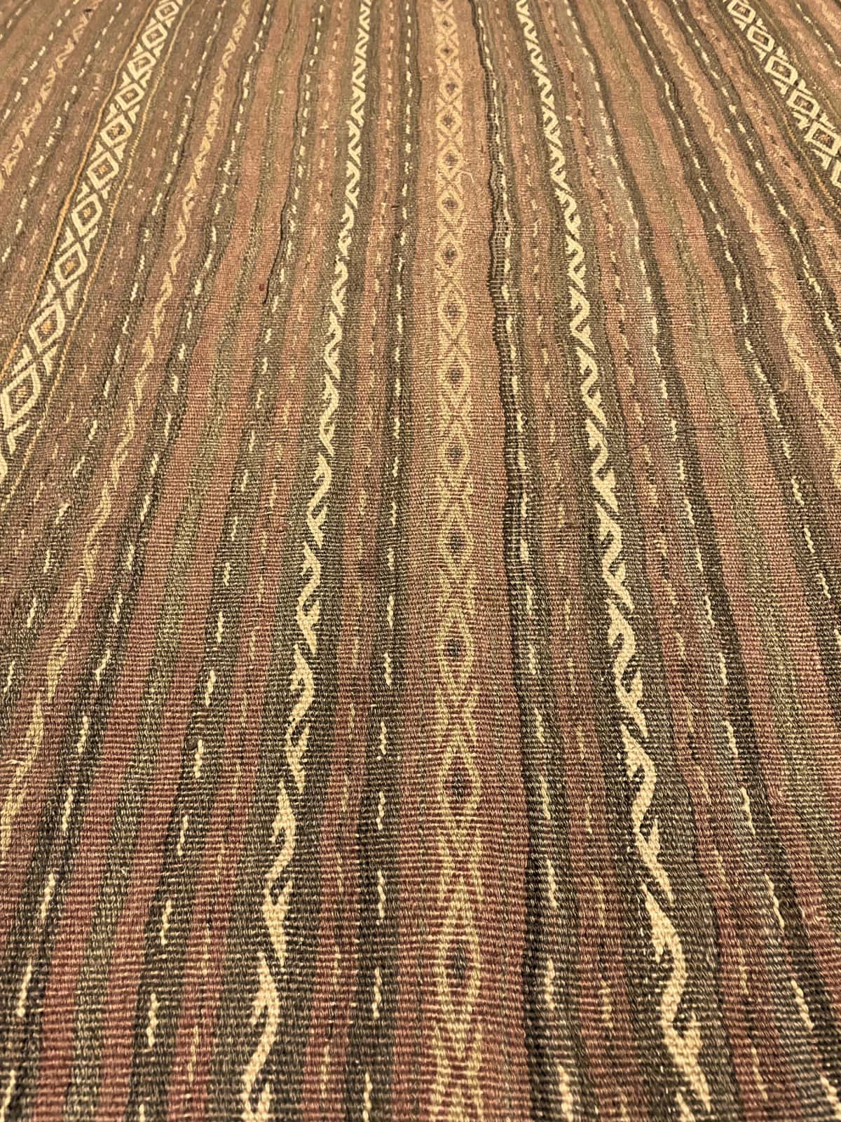 alfombra persa de estilo sumak en dimensiones 290 centímetros de largo por 153 centímetros de ancho con colores principalmente rojo y marrón — Primer plano de la textura