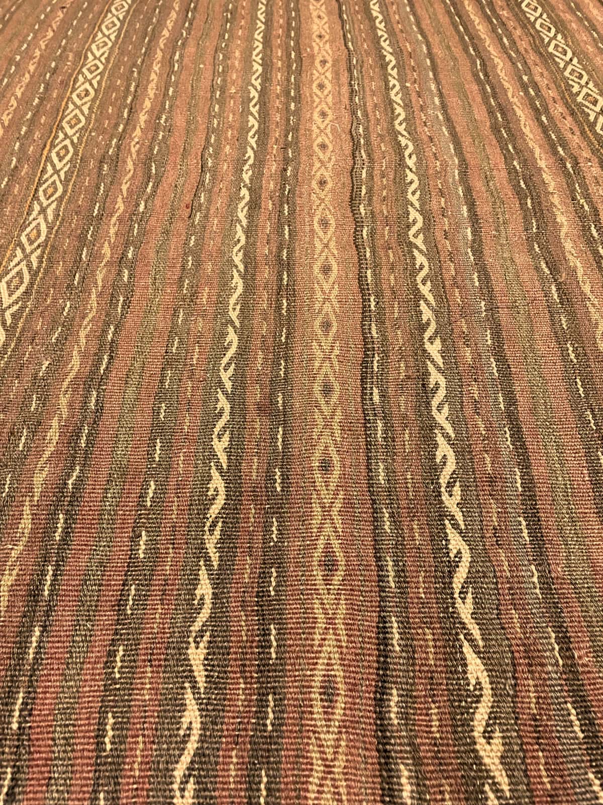 Persian rug of Sumak style in dimensions 290 centimeters length by 153 centimeters width with mainly red and brown colors — Texture close-up