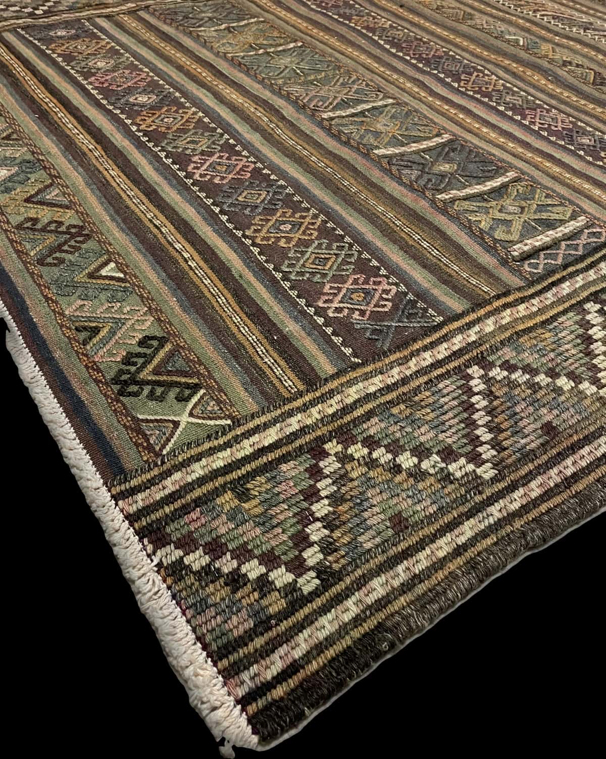 Persian rug of Sumak style in dimensions 206 centimeters length by 141 centimeters width with mainly green and purple colors — Corner & edge