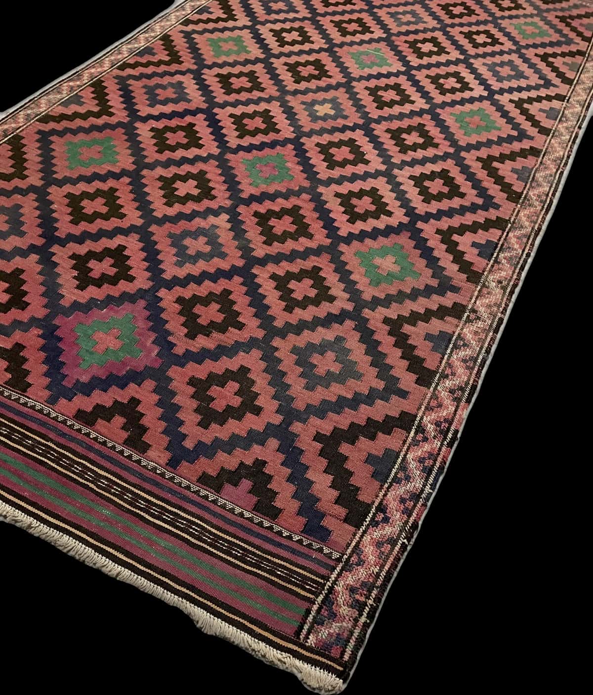 alfombra persa de estilo sumak en dimensiones 270 centímetros de largo por 135 centímetros de ancho con colores principalmente rojo y negro — Esquina y borde