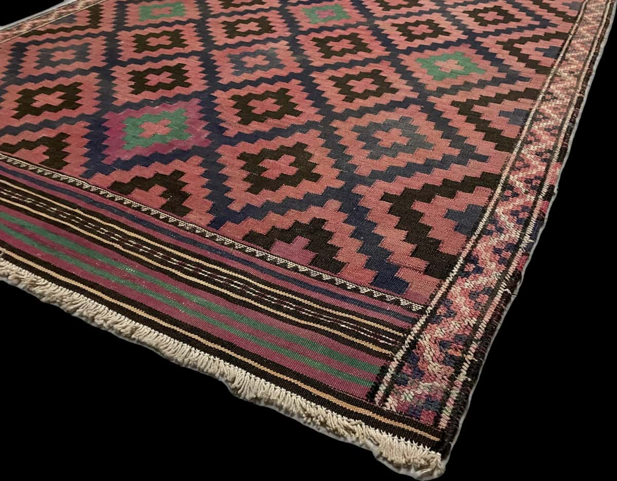alfombra persa de estilo sumak en dimensiones 270 centímetros de largo por 135 centímetros de ancho con colores principalmente rojo y negro — Esquina y borde