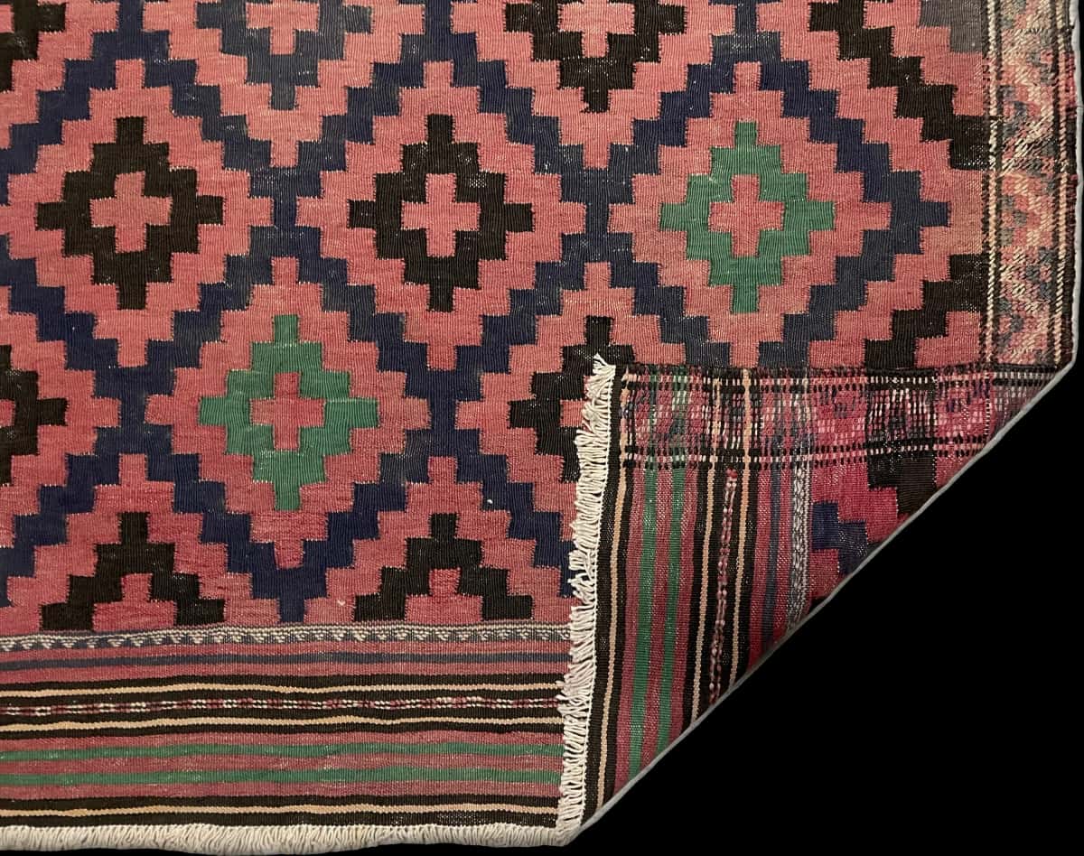 alfombra persa de estilo sumak en dimensiones 270 centímetros de largo por 135 centímetros de ancho con colores principalmente rojo y negro — Plegada