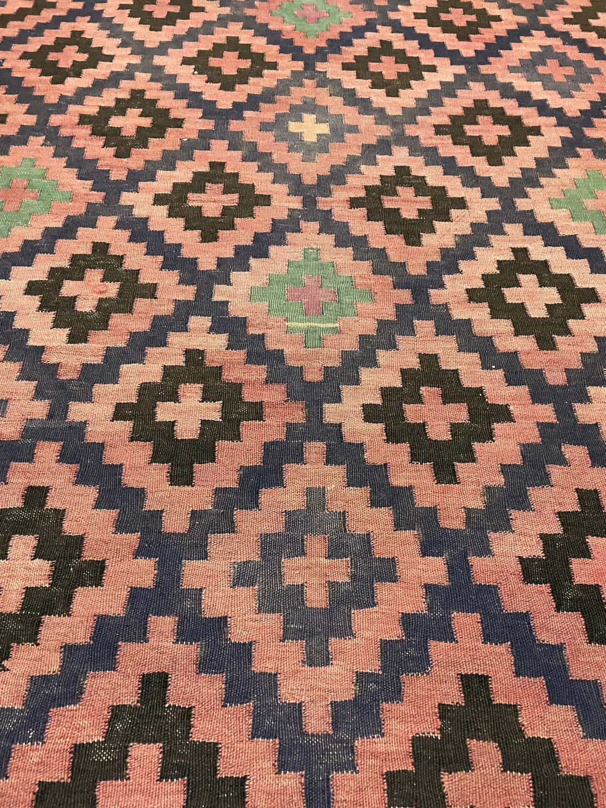 alfombra persa de estilo sumak en dimensiones 270 centímetros de largo por 135 centímetros de ancho con colores principalmente rojo y negro — Primer plano de la textura
