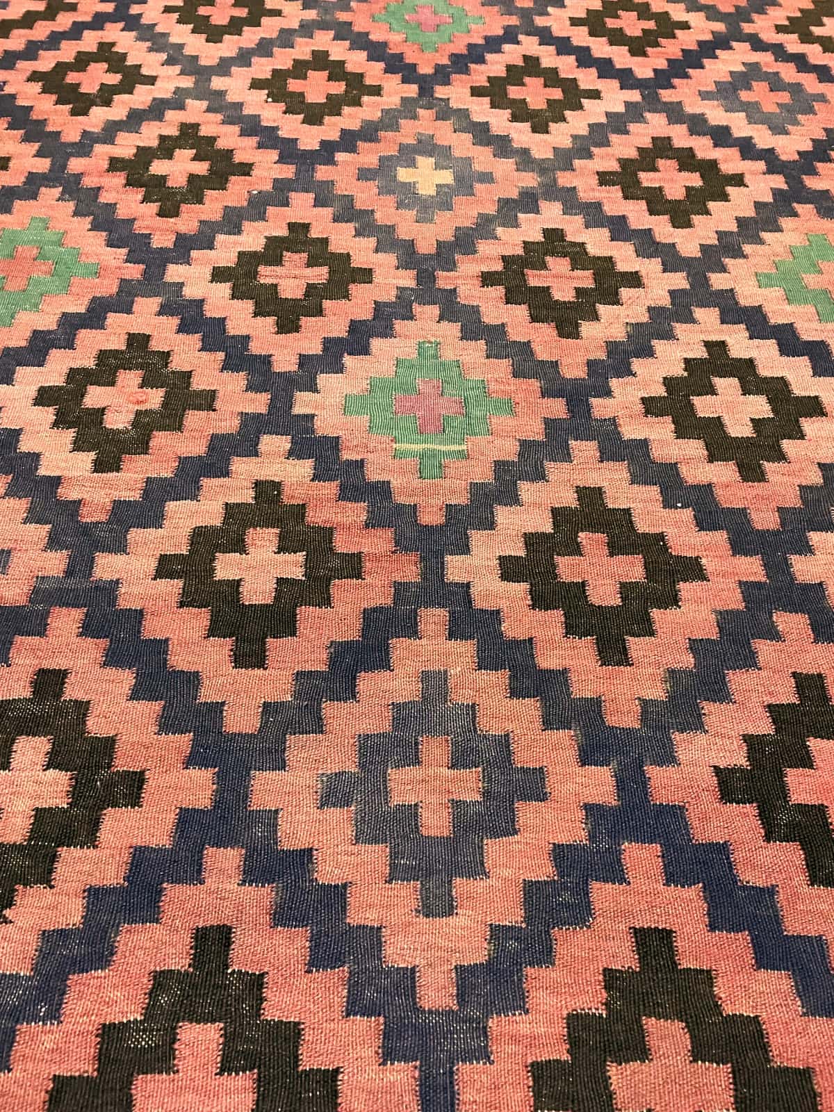 Persian rug of Sumak style in dimensions 270 centimeters length by 135 centimeters width with mainly red and black colors — Texture close-up