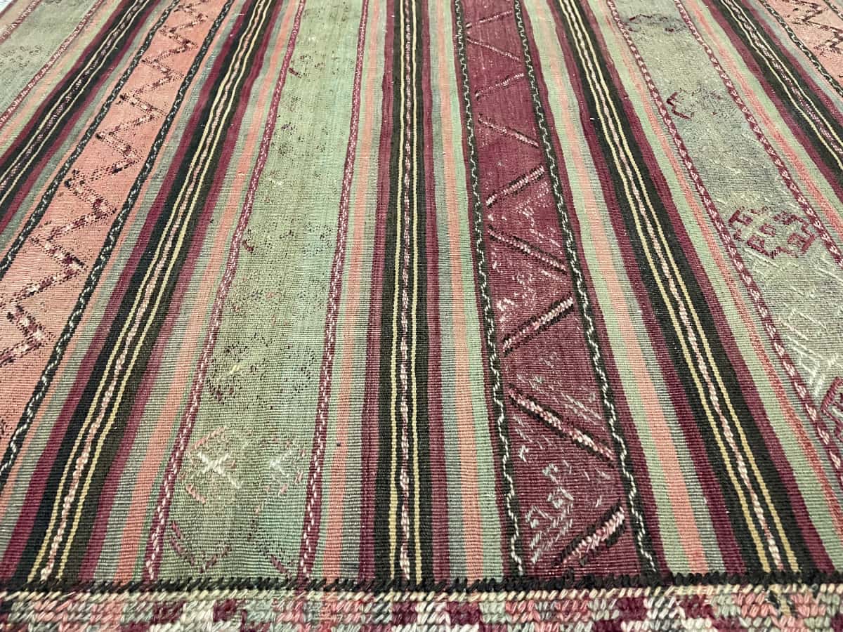 Persian rug of Sumak Kilim style in dimensions 200 centimeters length by 163 centimeters width with mainly green and purple colors — Texture close-up