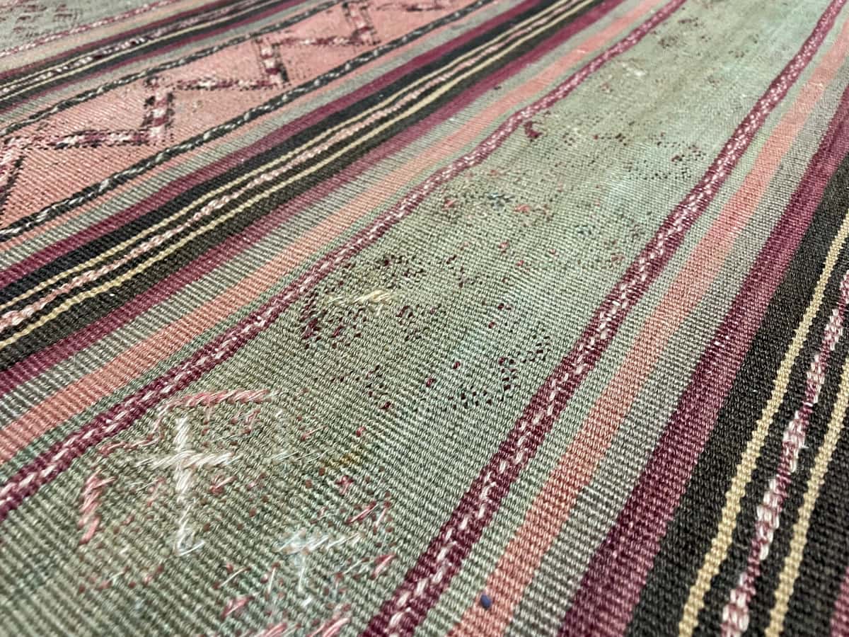 Persian rug of Sumak Kilim style in dimensions 200 centimeters length by 163 centimeters width with mainly green and purple colors — Texture close-up