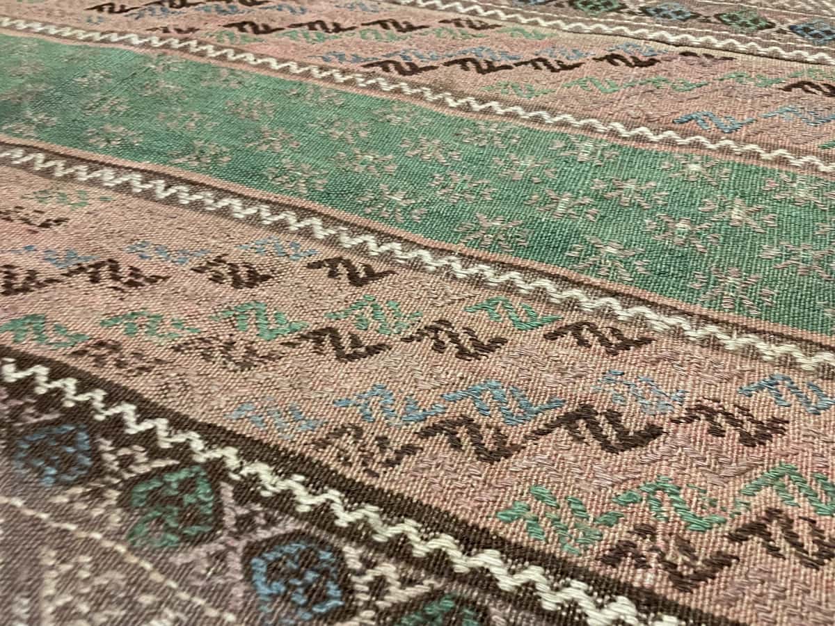 Persian rug of Sumak Kilim style in dimensions 233 centimeters length by 150 centimeters width with mainly brown colors — Texture close-up