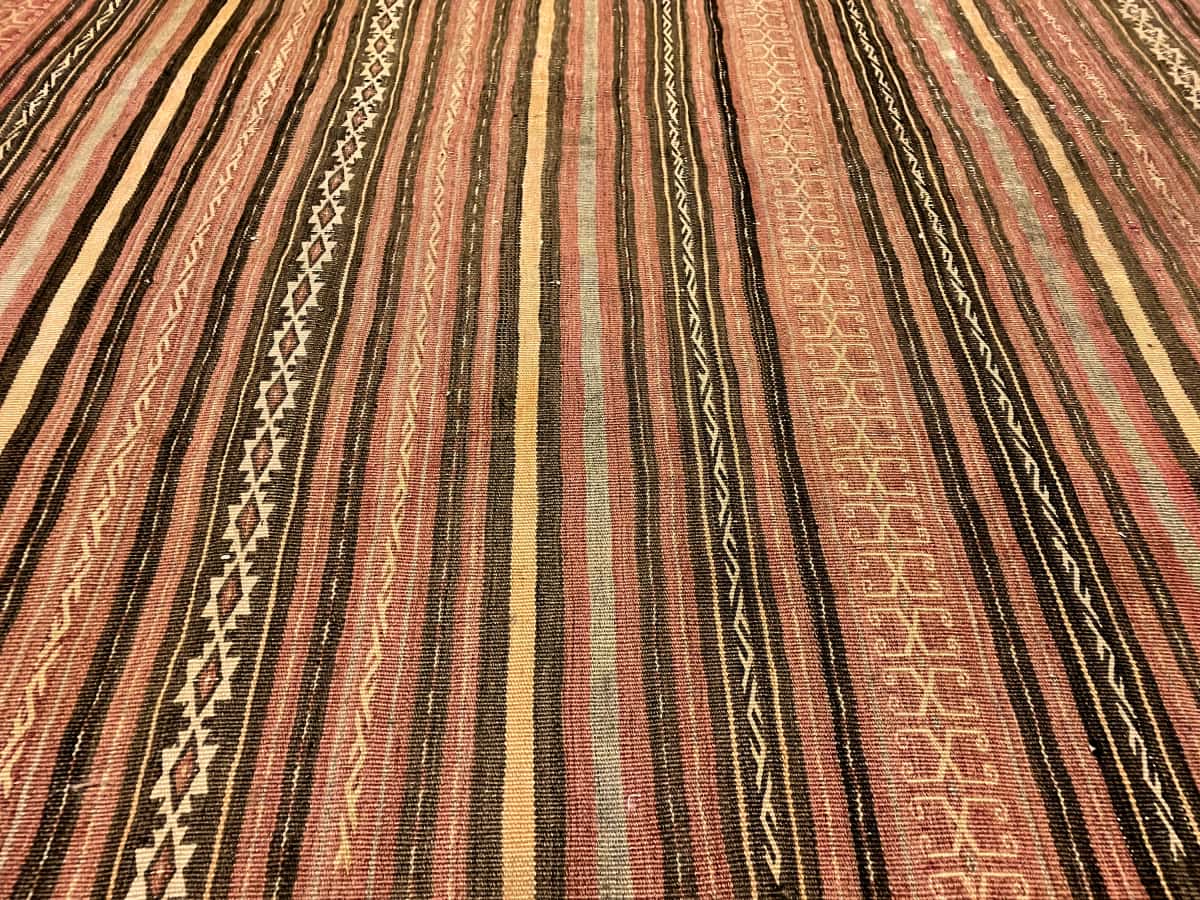 Persian rug of Sumak Kilim style in dimensions 200 centimeters length by 150 centimeters width with mainly brown colors — Texture close-up