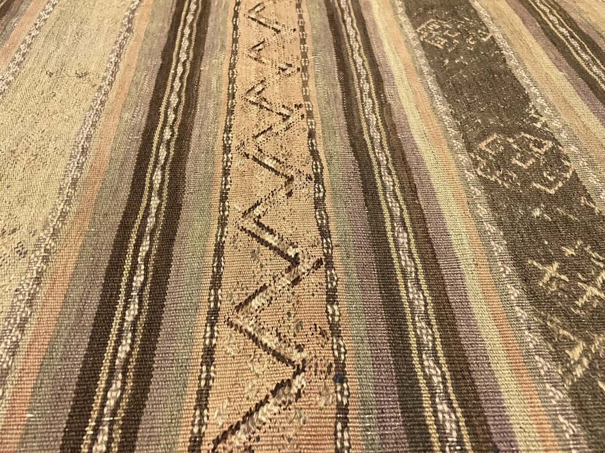 Persian rug of Sumak style in dimensions 268 centimeters length by 153 centimeters width with mainly green and brown colors — Texture close-up