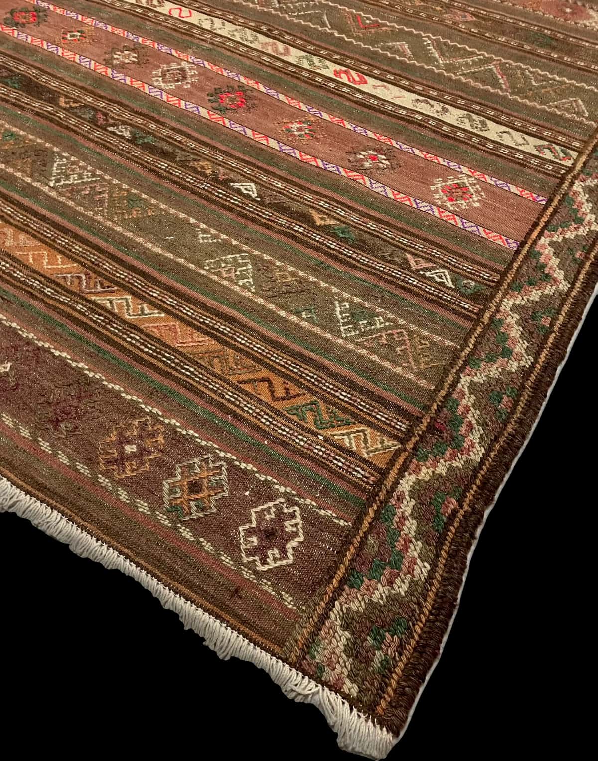 Persian rug of Sumak style in dimensions 260 centimeters length by 145 centimeters width with mainly brown and green colors — Corner & edge