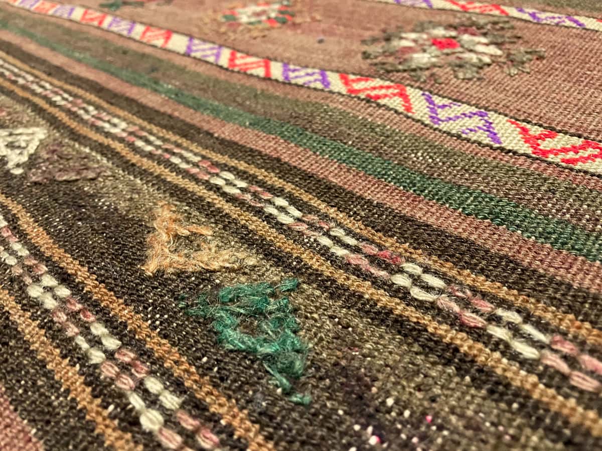 Persian rug of Sumak style in dimensions 260 centimeters length by 145 centimeters width with mainly brown and green colors — Texture close-up