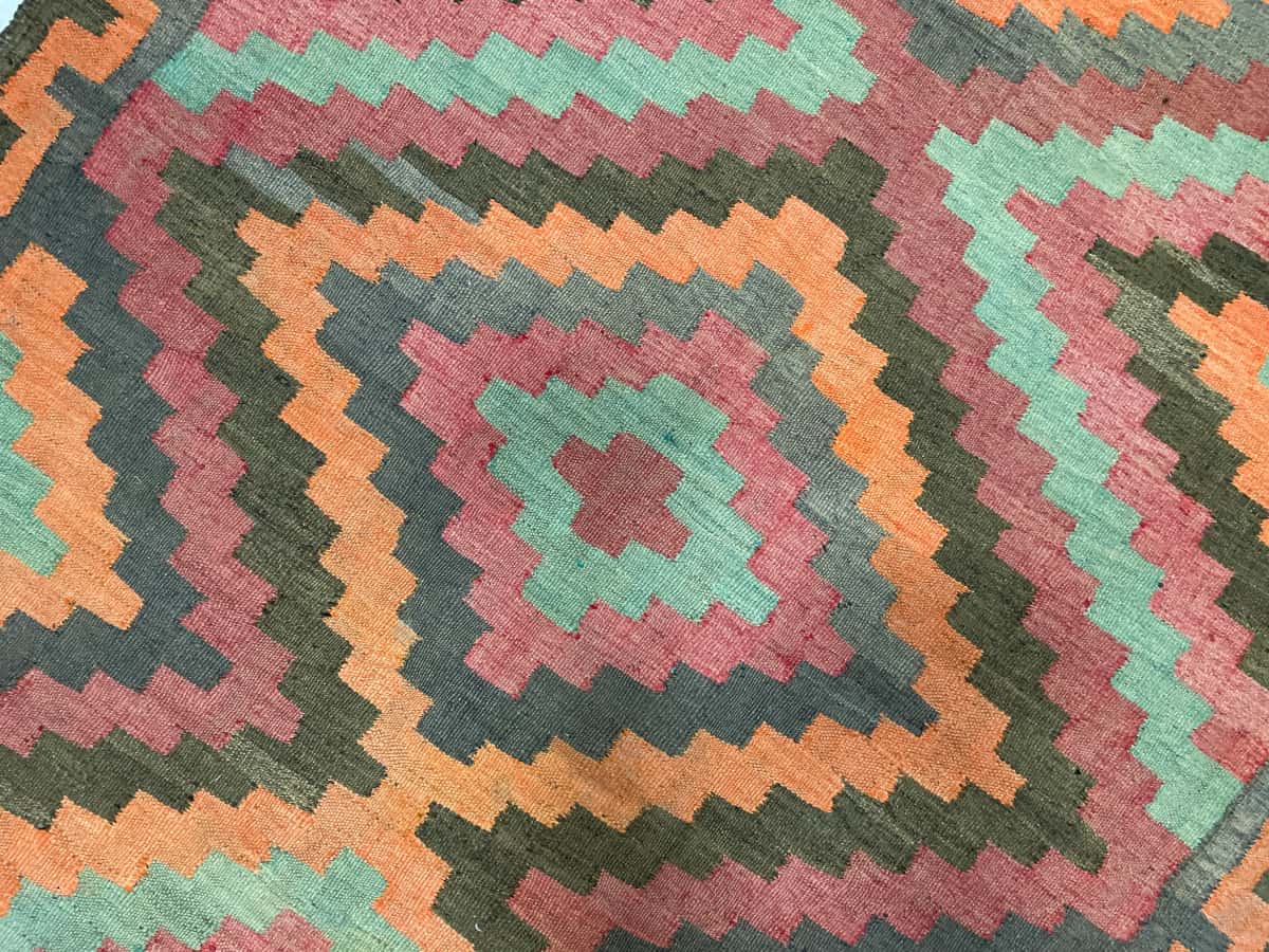 Persian rug of Khorasan style in dimensions 133 centimeters length by 130 centimeters width with mainly orange and red colors — Texture close-up