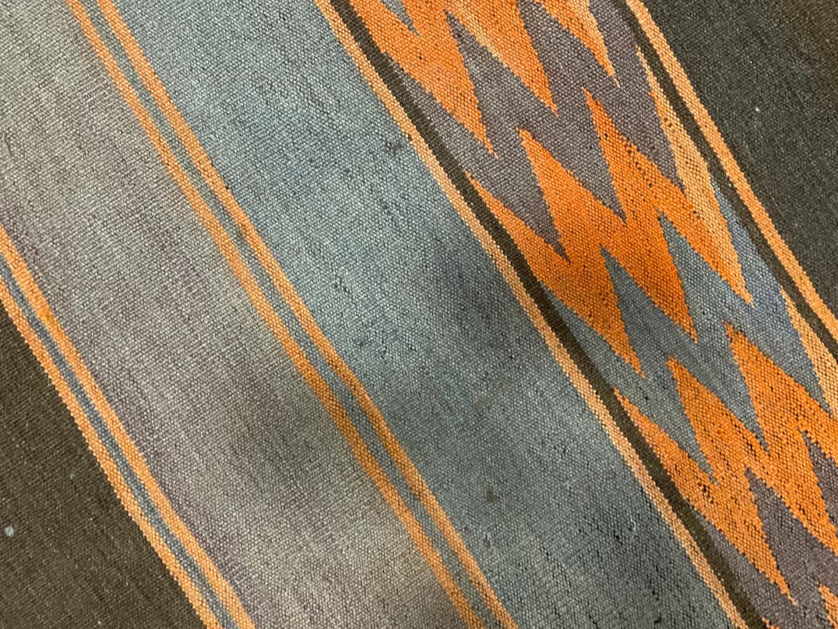 persischer Teppich im Kilim Stil in den Maßen 137 Zentimeter Länge mal 115 Zentimeter Breite mit überwiegend orange und braun Farben — Nahaufnahme der Textur
