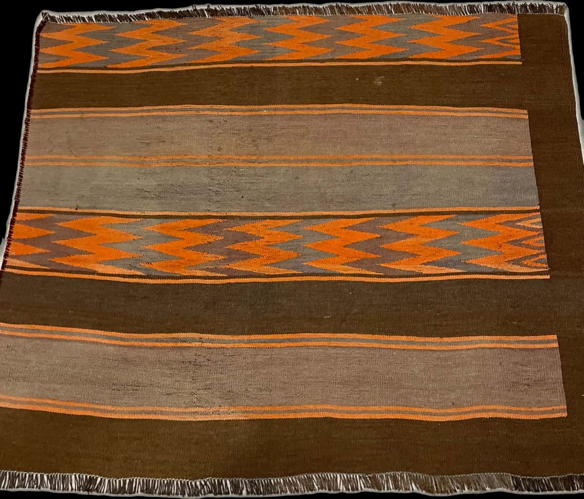 persischer Teppich im Kilim Stil in den Maßen 137 Zentimeter Länge mal 115 Zentimeter Breite mit überwiegend orange und braun Farben — Perspektive