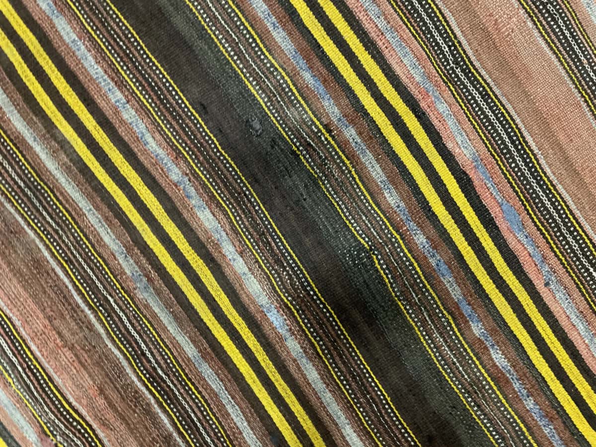 Persian rug of Sumak style in dimensions 141 centimeters length by 117 centimeters width with mainly yellow and brown colors — Texture close-up