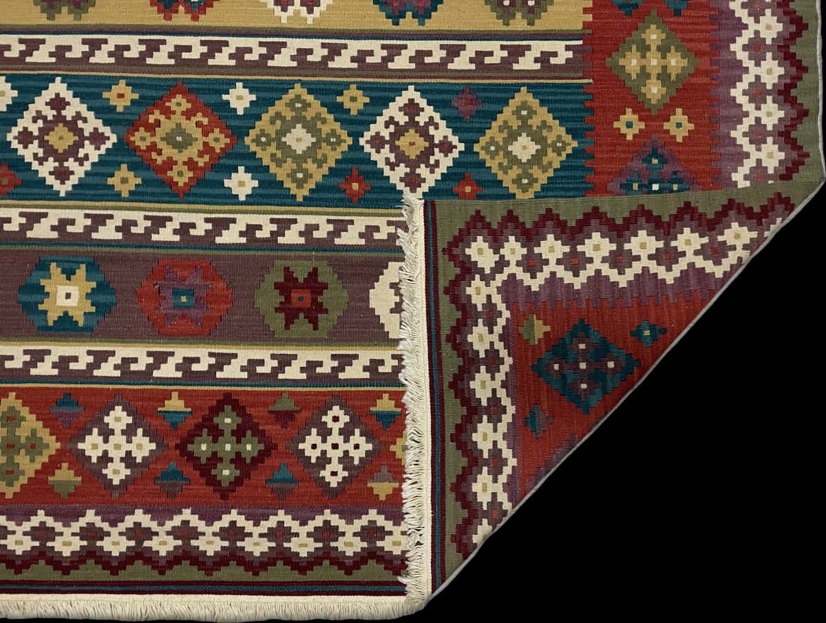 alfombra turca de estilo alfombra kilim en dimensiones 207 centímetros de largo por 205 centímetros de ancho con colores principalmente rojo y azul — Plegada