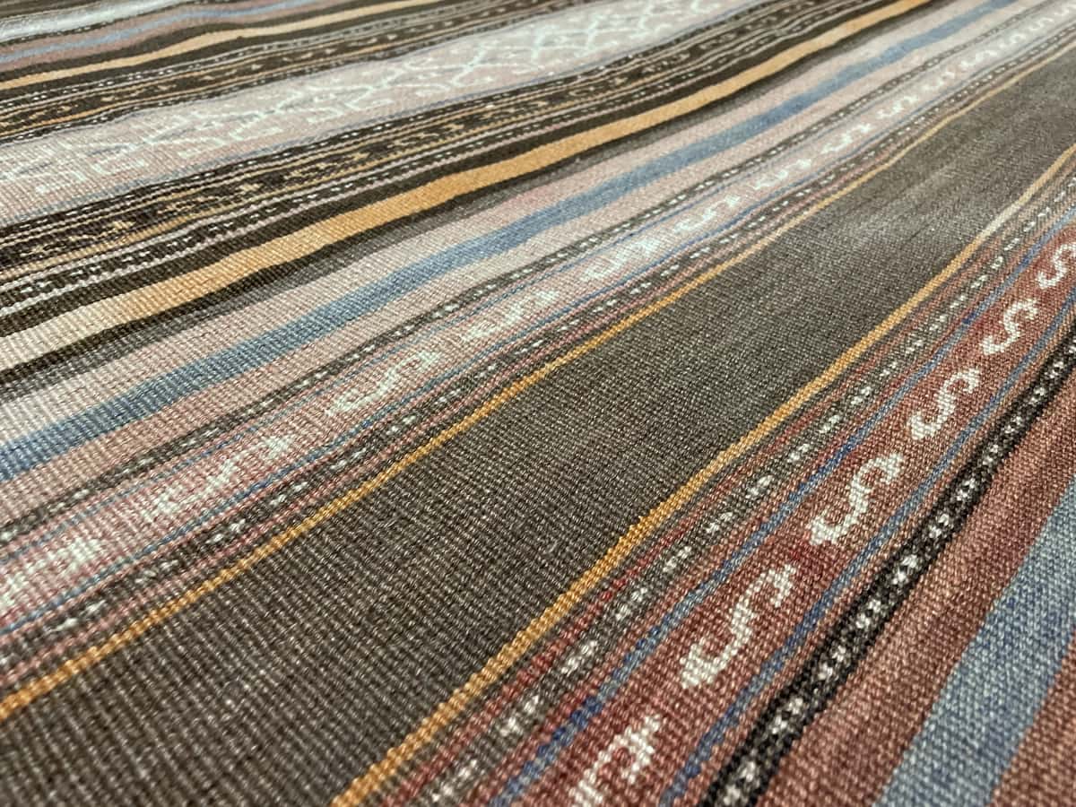 Persian rug of Sumak style in dimensions 180 centimeters length by 145 centimeters width with mainly orange colors — Texture close-up