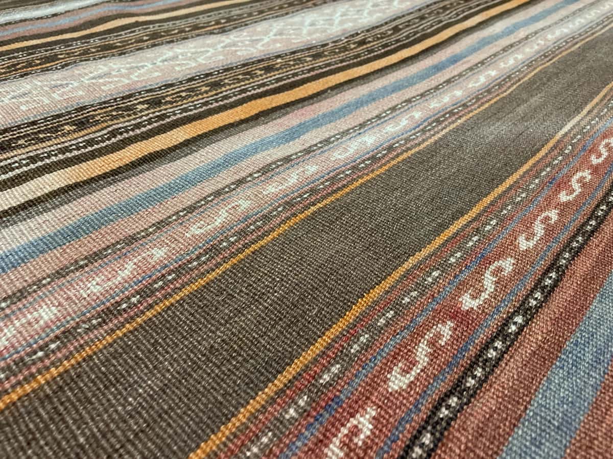 Persian rug of Sumak style in dimensions 180 centimeters length by 145 centimeters width with mainly orange colors — Texture close-up