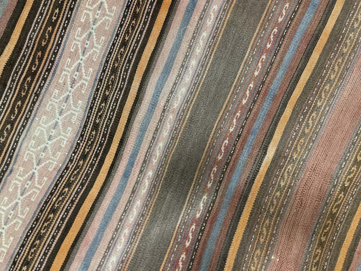 Persian rug of Sumak style in dimensions 180 centimeters length by 145 centimeters width with mainly orange colors — Texture close-up