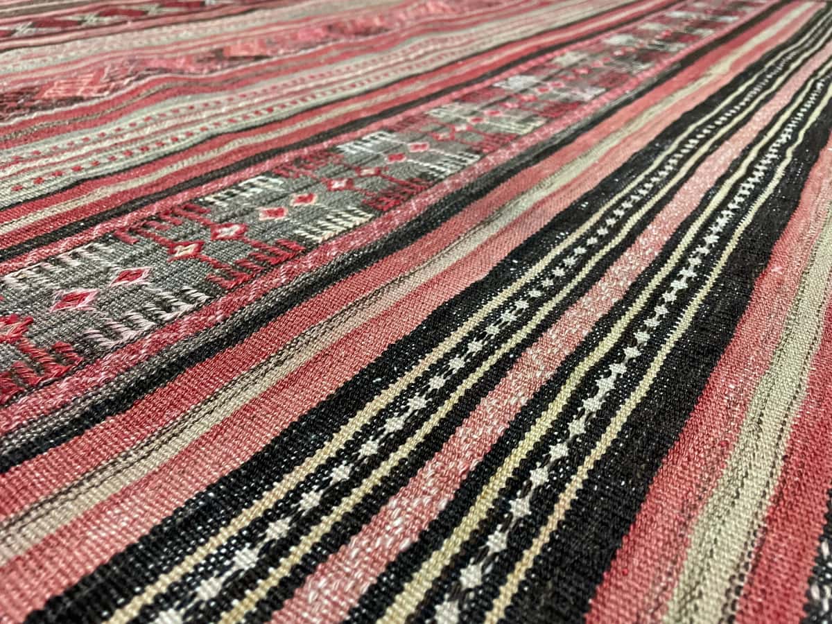 Persian rug of Sumak style in dimensions 165 centimeters length by 154 centimeters width with mainly red colors — Texture close-up