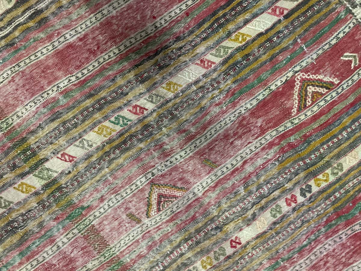 Persian rug of Sumak style in dimensions 216 centimeters length by 150 centimeters width with mainly red and yellow colors — Texture close-up