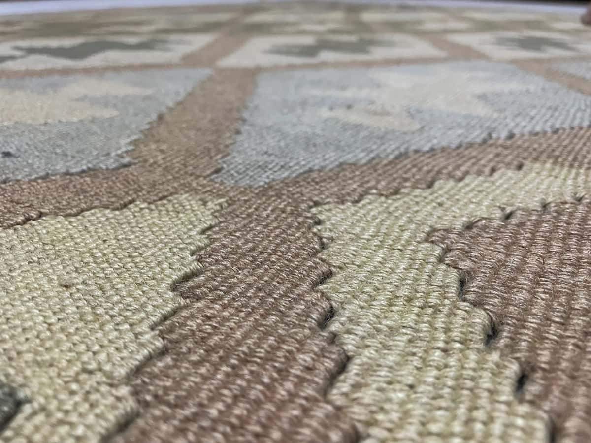 alfombra persa de estilo kilim en dimensiones 225 centímetros de largo por 140 centímetros de ancho con colores principalmente verde y amarillo — Primer plano de la textura