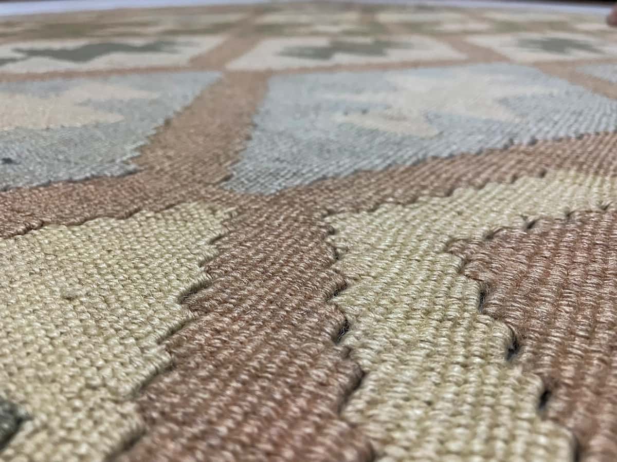 Persian rug of Kilim style in dimensions 225 centimeters length by 140 centimeters width with mainly green and yellow colors — Texture close-up