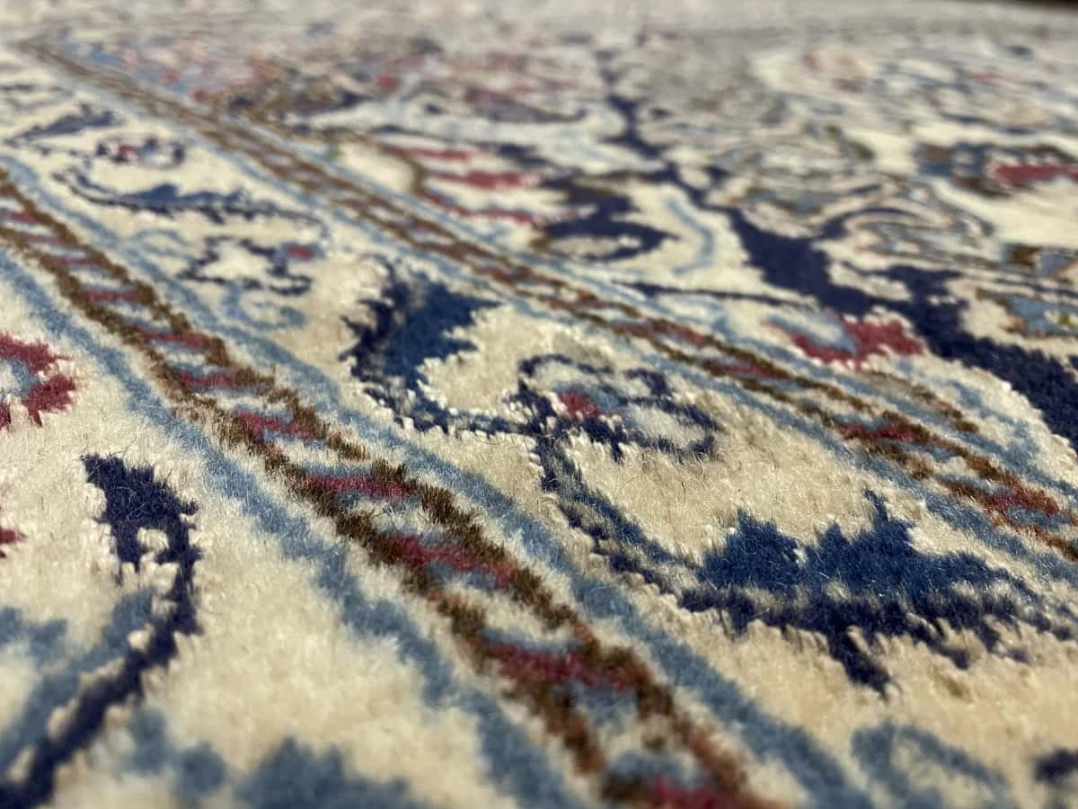 Persian rug of Nain style in dimensions 200 centimeters length by 192 centimeters width with mainly beige and red colors — Texture close-up