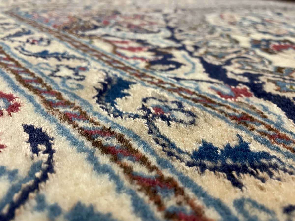persischer Teppich im Nain Stil in den Maßen 200 Zentimeter Länge mal 192 Zentimeter Breite mit überwiegend beige und rot Farben — Nahaufnahme der Textur