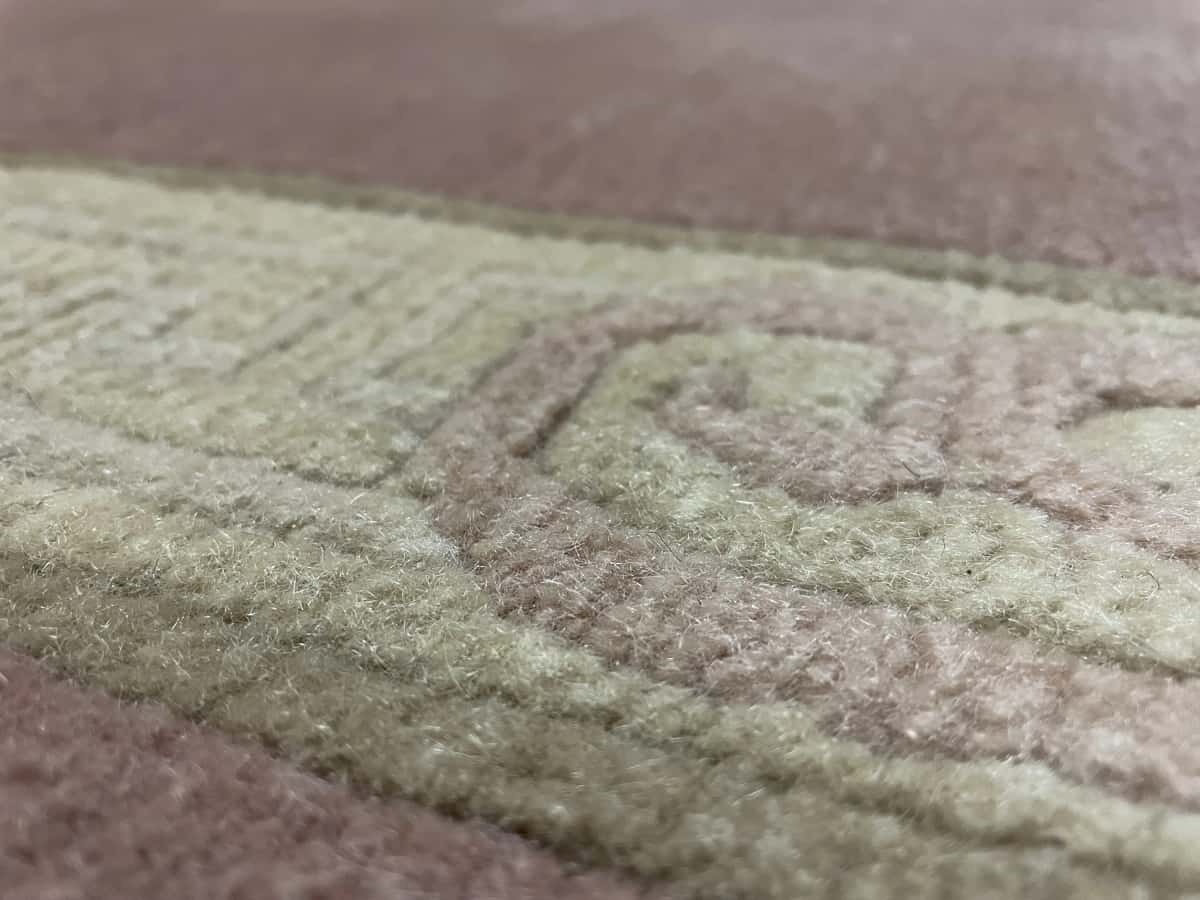 Nepali rug of Tibetan style in dimensions 255 centimeters length by 202 centimeters width with mainly pink colors — Texture close-up