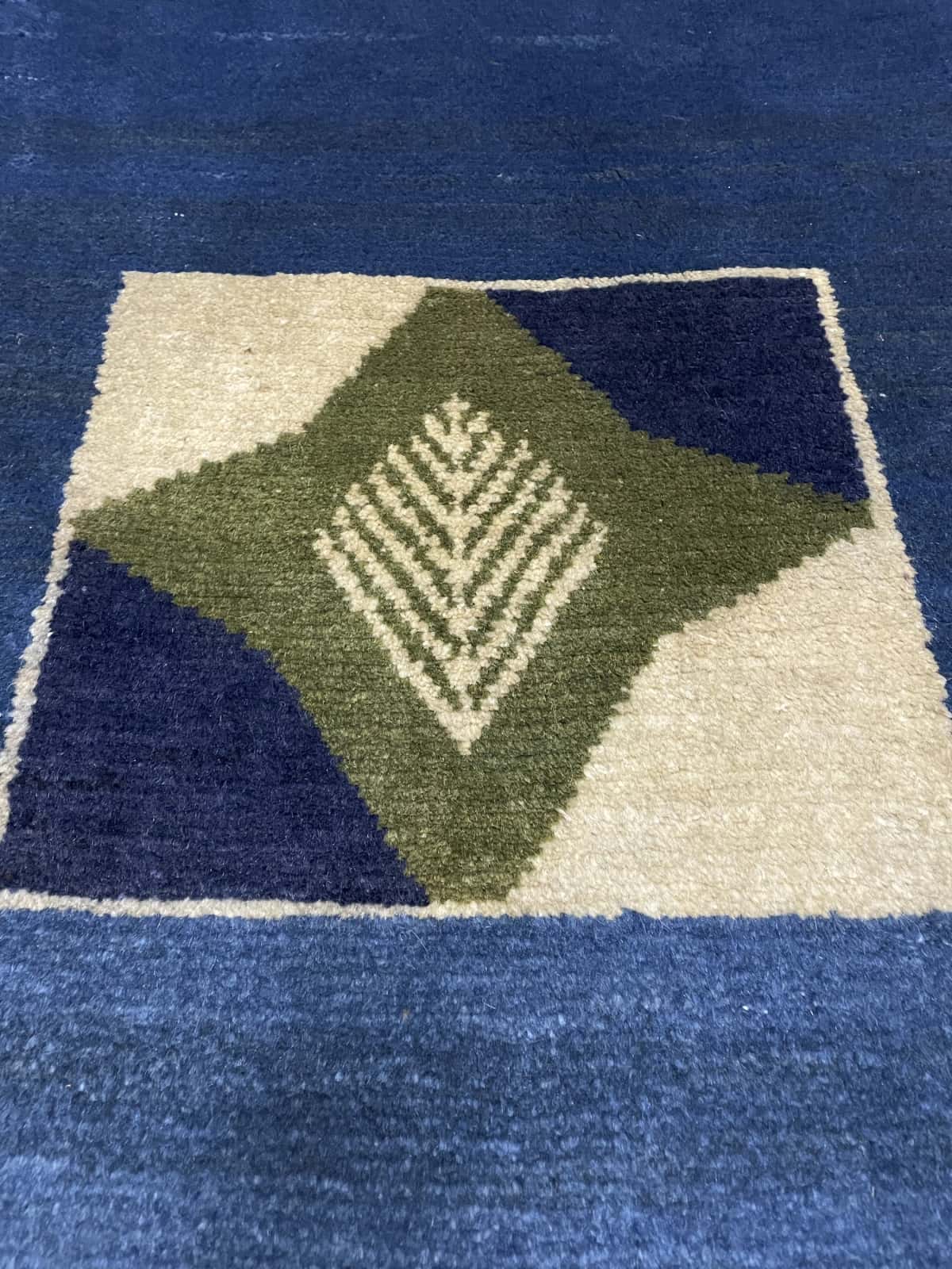 alfombra persa de estilo gabbeh en dimensiones 150 centímetros de largo por 102 centímetros de ancho con colores principalmente verde — Primer plano de la textura
