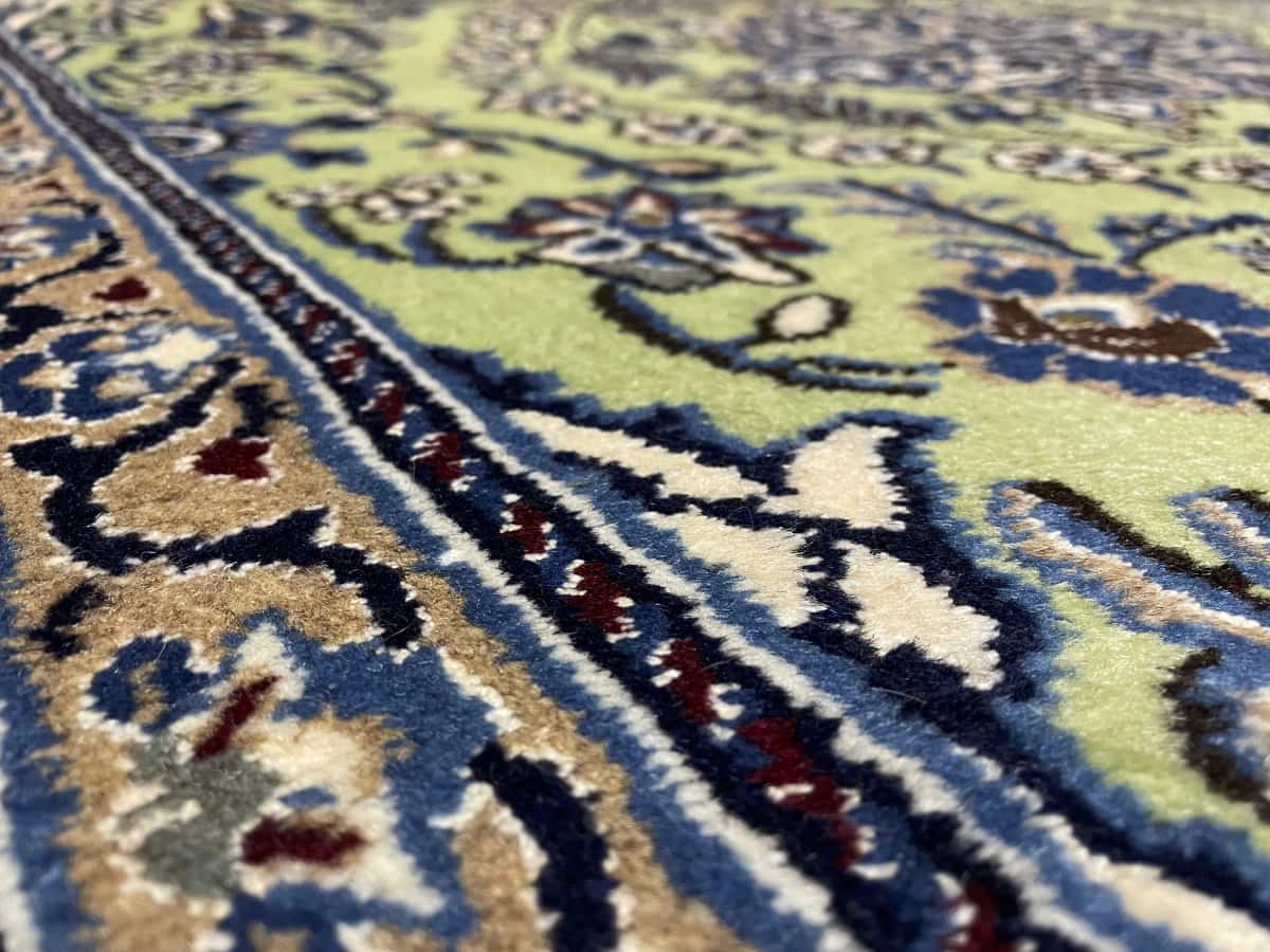 Persian rug of Nain style in dimensions 208 centimeters length by 146 centimeters width with mainly green and blue colors — Texture close-up
