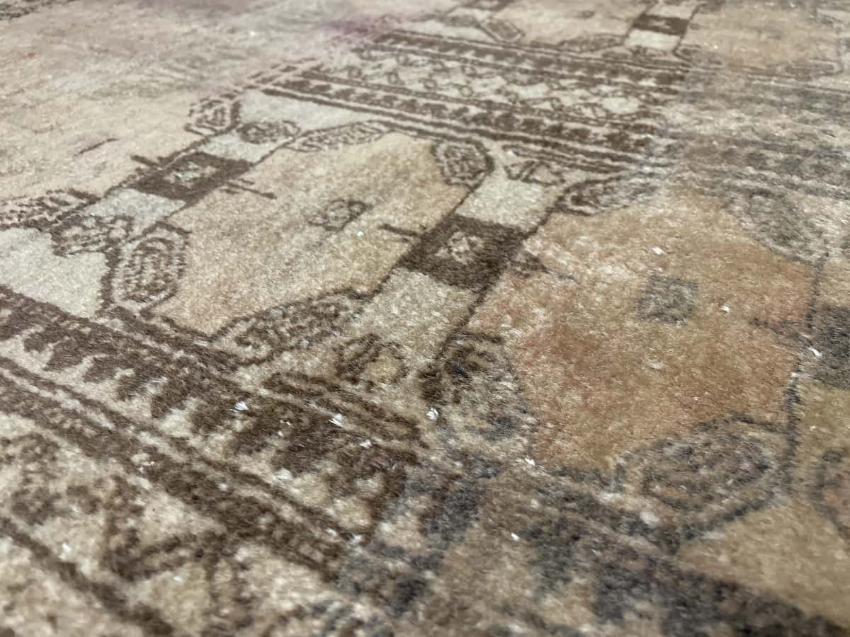 Persian rug of Baluch style in dimensions 182 centimeters length by 94 centimeters width with mainly brown colors — Texture close-up