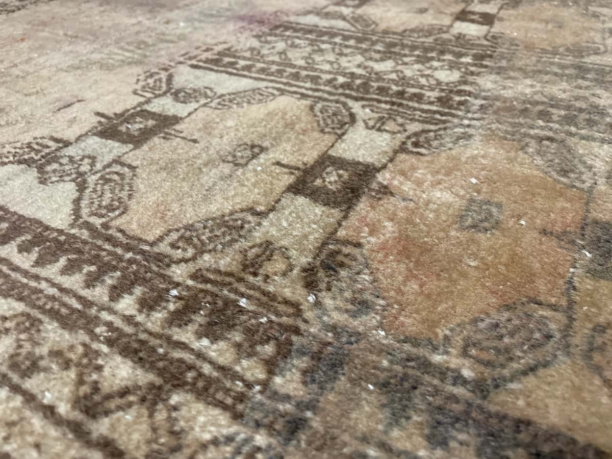 Persian rug of Baluch style in dimensions 182 centimeters length by 94 centimeters width with mainly brown colors — Texture close-up
