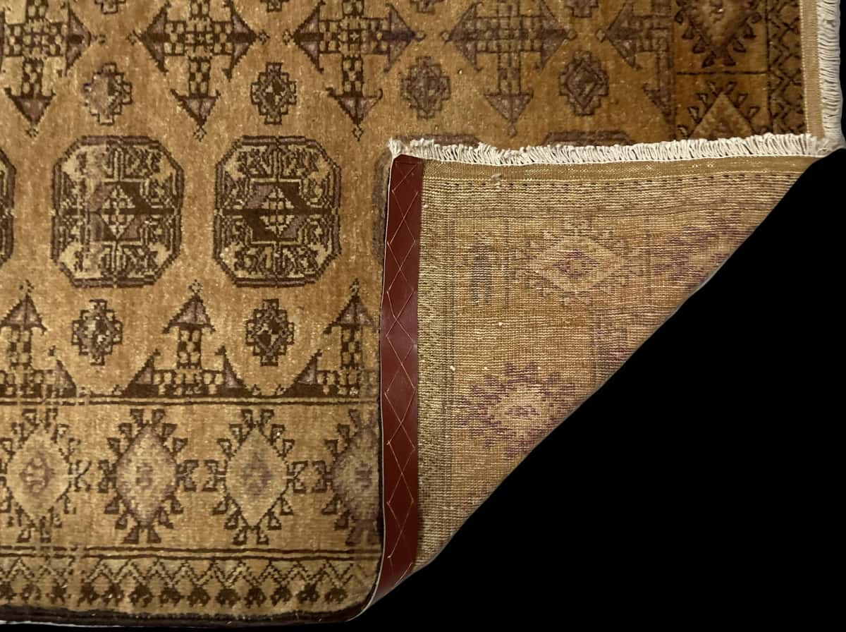 alfombra persa de estilo baluch en dimensiones 204 centímetros de largo por 117 centímetros de ancho con colores principalmente marrón — Plegada