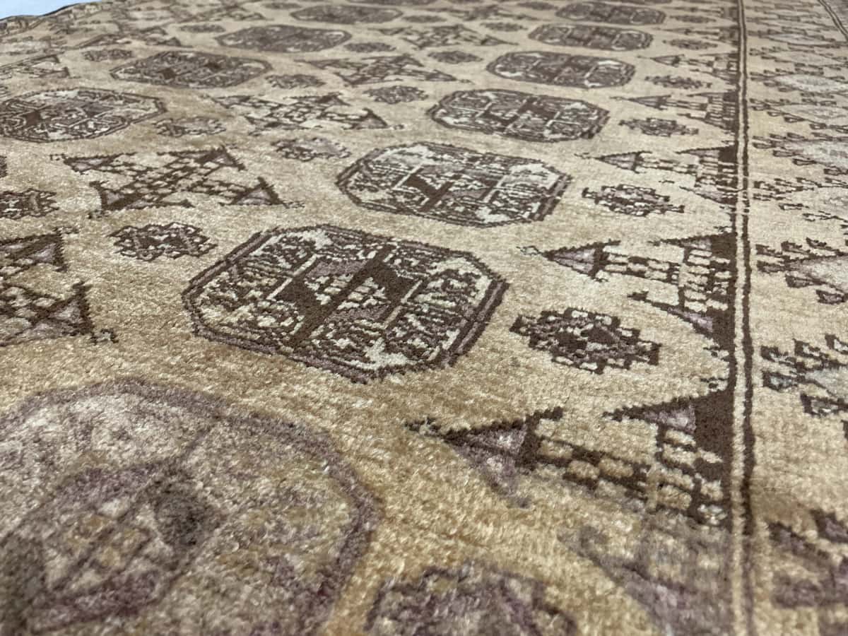 alfombra persa de estilo baluch en dimensiones 204 centímetros de largo por 117 centímetros de ancho con colores principalmente marrón — Primer plano de la textura