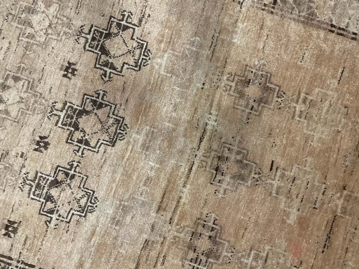 Persian rug of Baluch style in dimensions 220 centimeters length by 117 centimeters width with mainly brown colors — Texture close-up