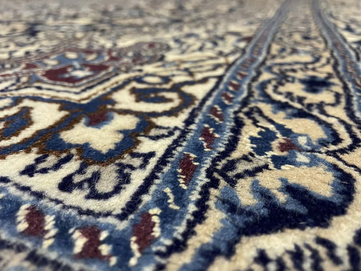 Persian rug of Nain style in dimensions 208 centimeters length by 198 centimeters width with mainly beige and blue colors — Texture close-up