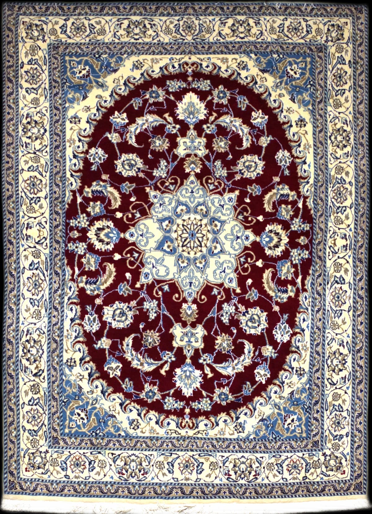alfombra persa de estilo Nain en dimensiones 242 centímetros de largo por 163 centímetros de ancho con colores principalmente rojo