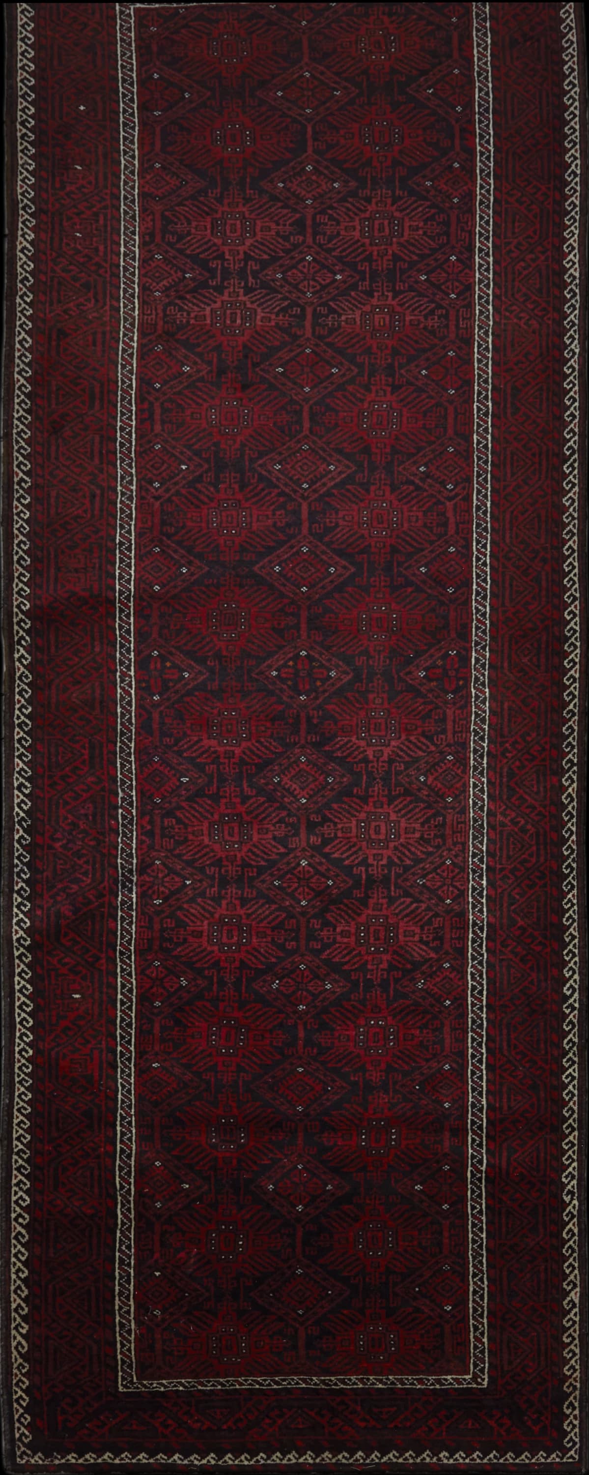 alfombra persa en dimensiones 360 centímetros de largo por 117 centímetros de ancho con colores principalmente rojo