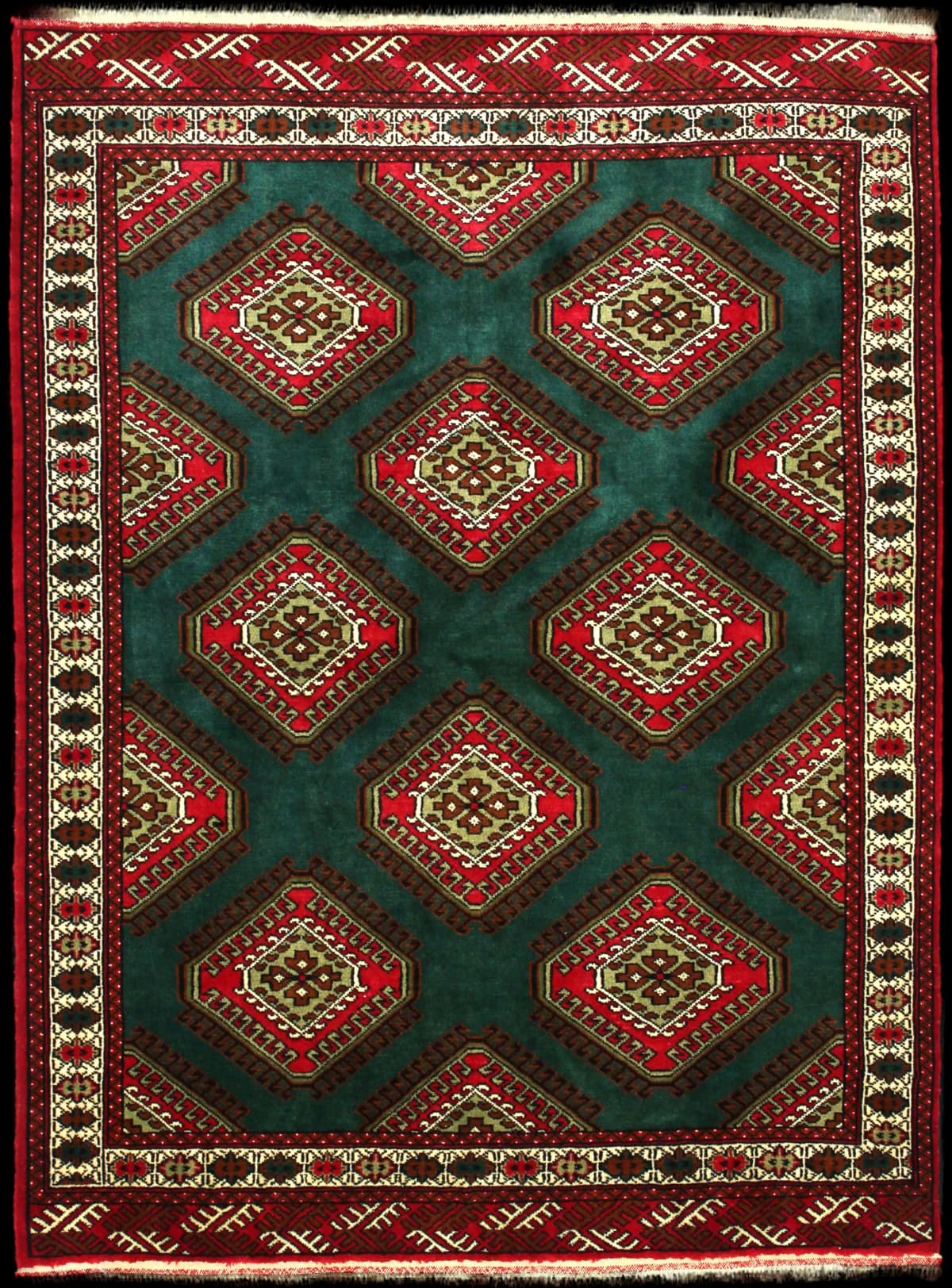alfombra persa de estilo turcomana en dimensiones 183 centímetros de largo por 137 centímetros de ancho con colores principalmente verde