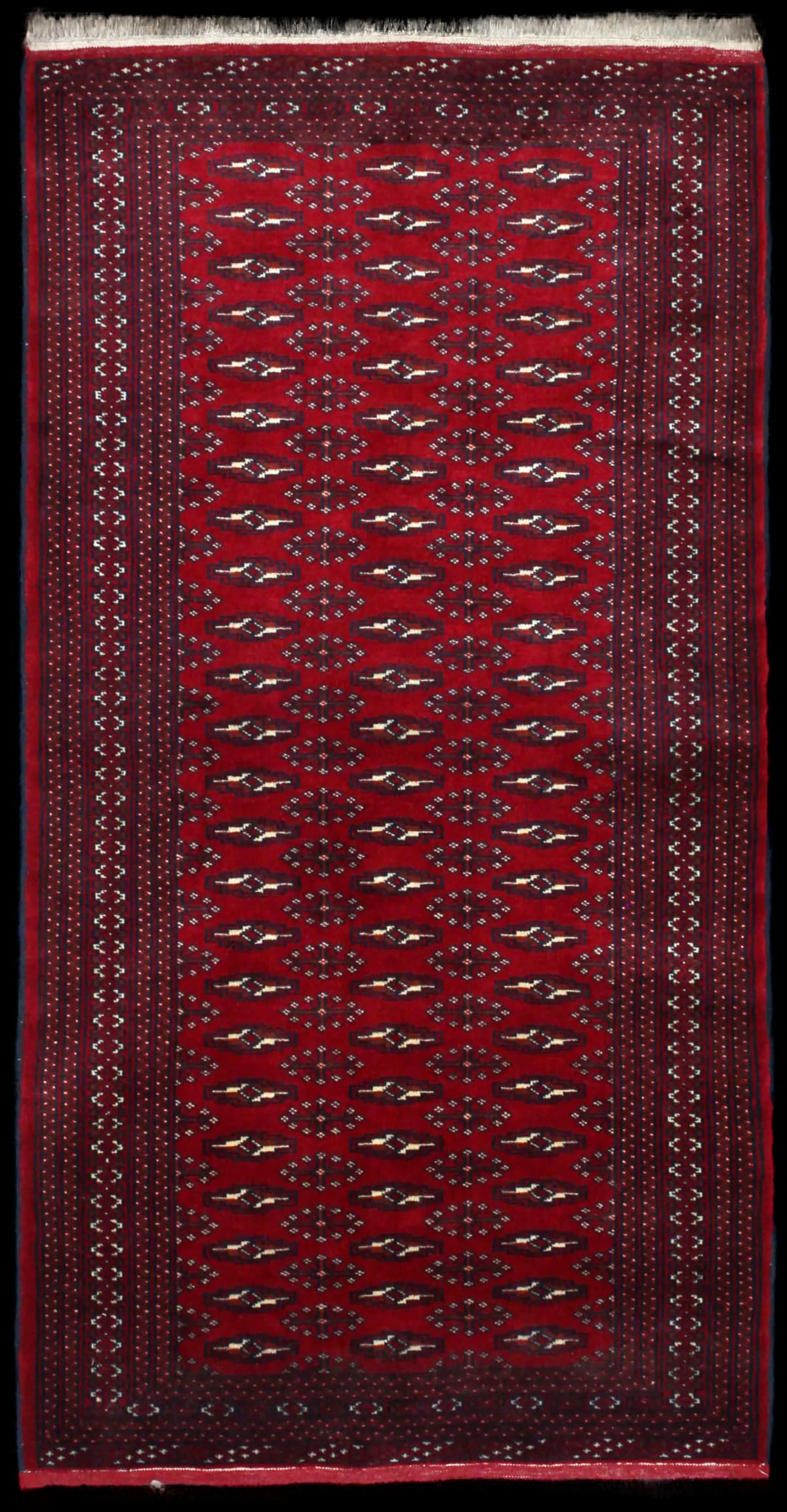 alfombra persa de estilo turcomana en dimensiones 200 centímetros de largo por 102 centímetros de ancho con colores principalmente rojo