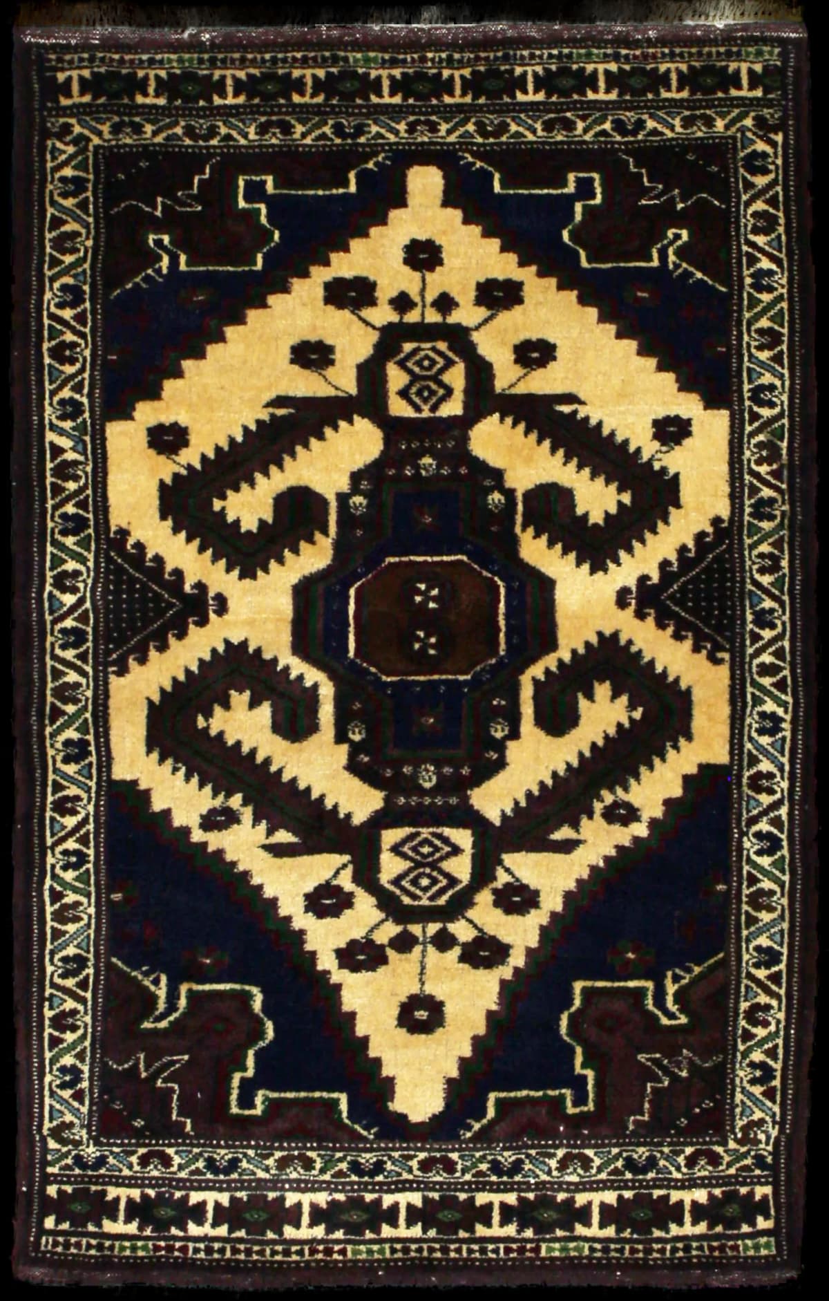 alfombra persa de estilo turcomana en dimensiones 132 centímetros de largo por 78 centímetros de ancho con colores principalmente marrón y amarillo