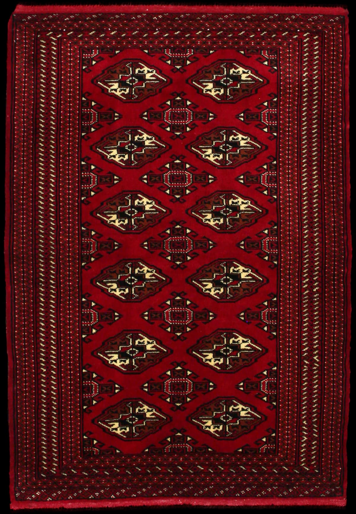 alfombra persa de estilo turcomana en dimensiones 150 centímetros de largo por 103 centímetros de ancho con colores principalmente rojo