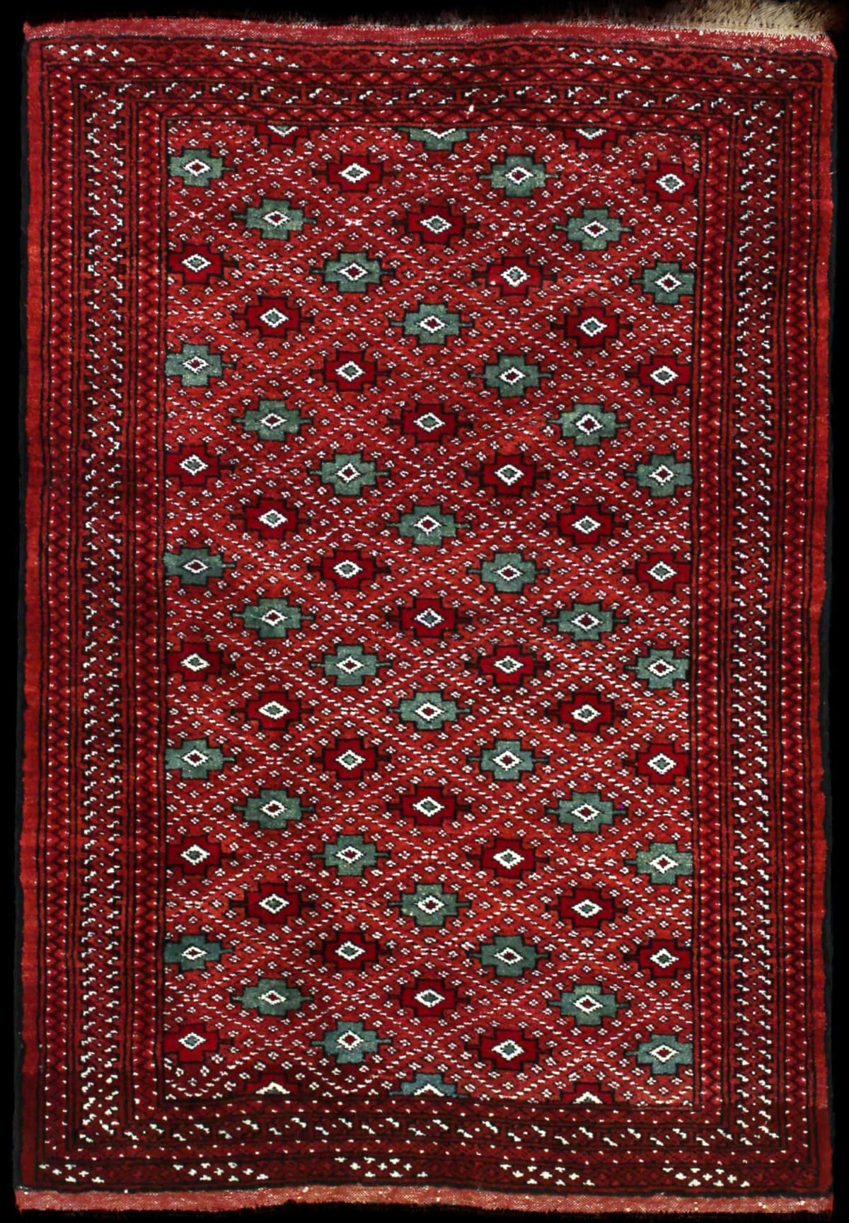 alfombra persa de estilo turcomana en dimensiones 150 centímetros de largo por 102 centímetros de ancho con colores principalmente marrón y rojo