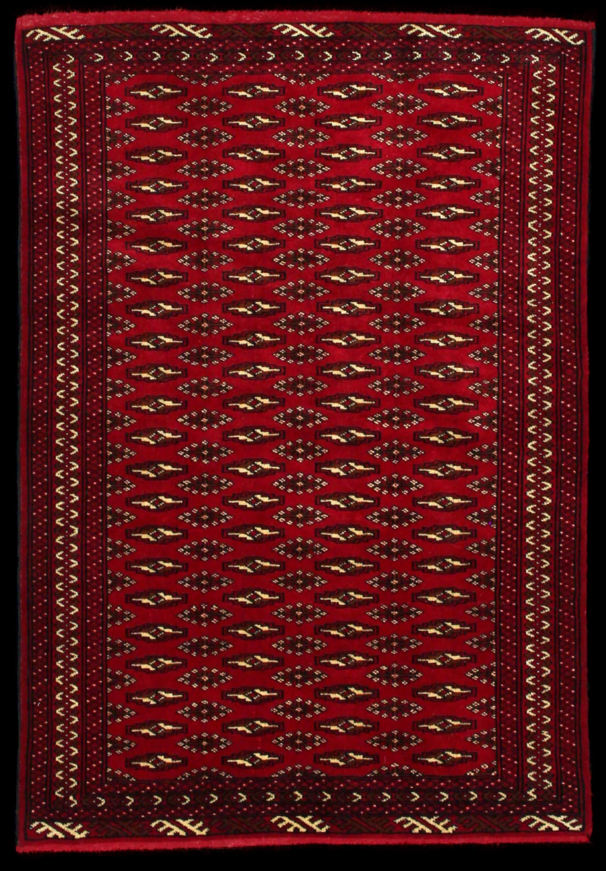 alfombra persa de estilo turcomana en dimensiones 148 centímetros de largo por 101 centímetros de ancho con colores principalmente rojo
