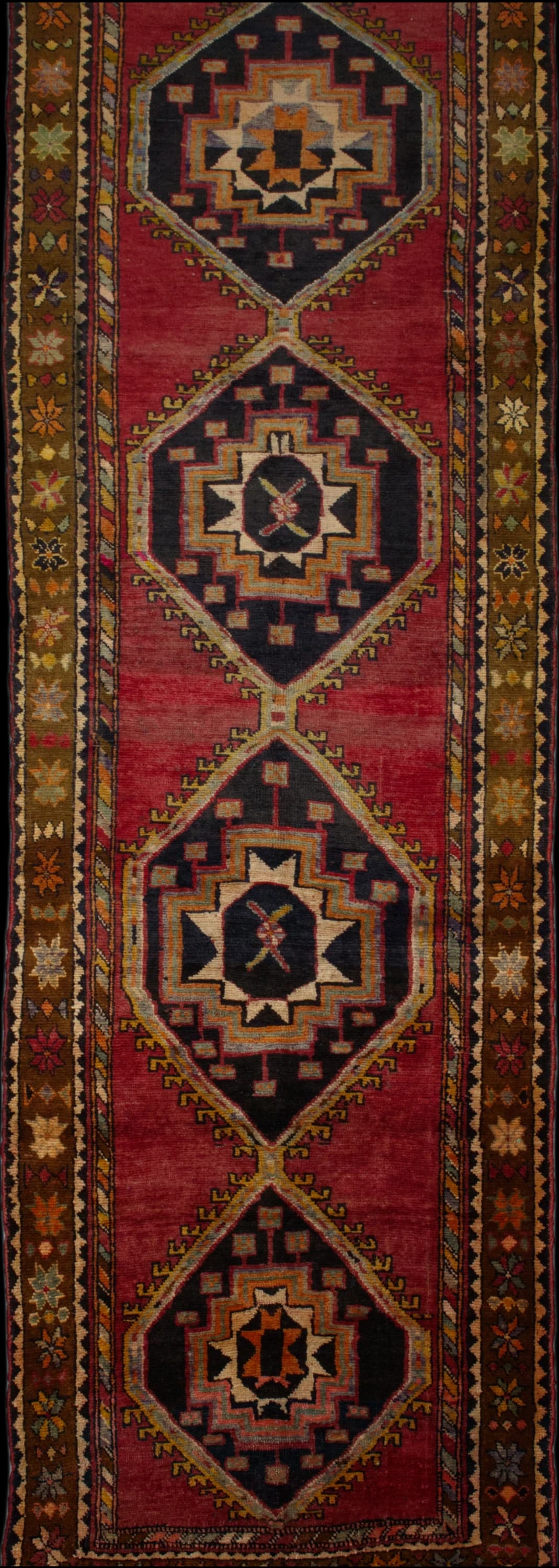 alfombra persa en dimensiones 395 centímetros de largo por 110 centímetros de ancho con colores principalmente rojo