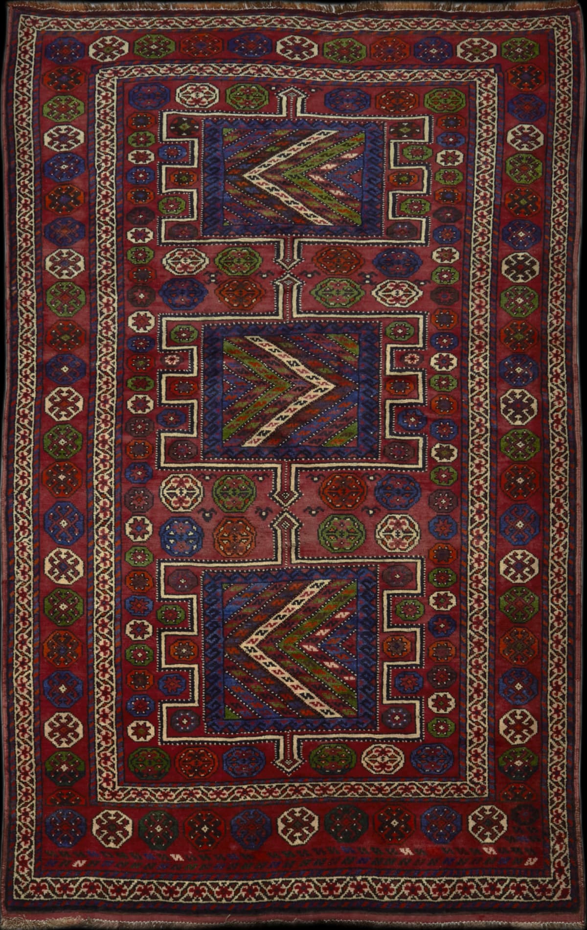 alfombra persa en dimensiones 266 centímetros de largo por 155 centímetros de ancho con colores principalmente rojo