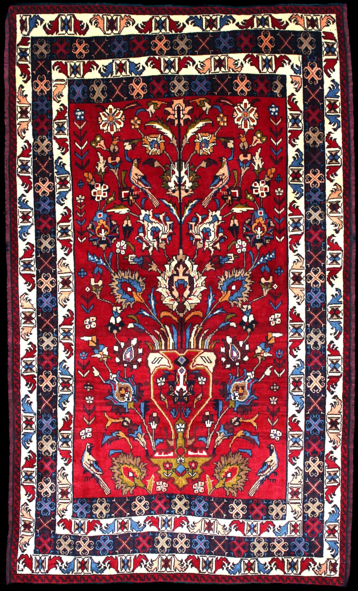 alfombra persa de estilo baluch en dimensiones 220 centímetros de largo por 137 centímetros de ancho con colores principalmente rojo y azul